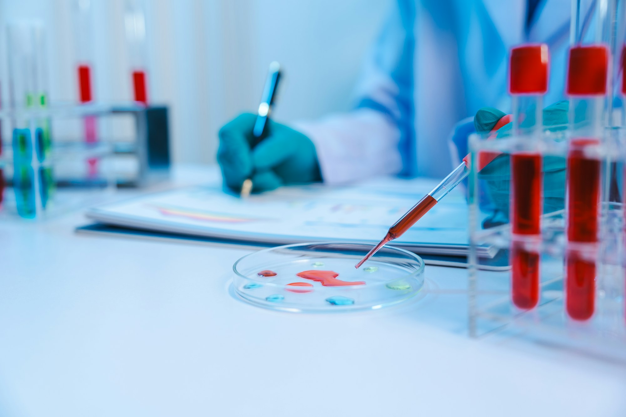 Asian people scientist in lab coat and protective gloves working with test tubes